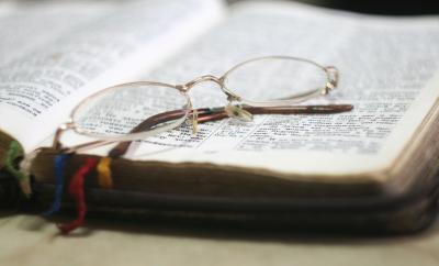 Open Bible with glasses resting on top